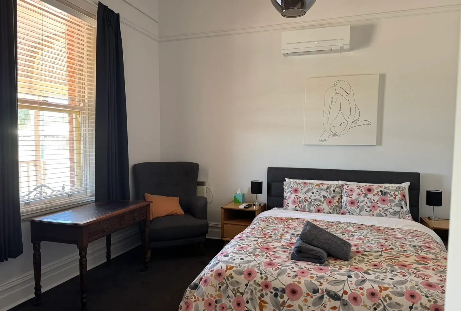 image-1 A bedroom with a bed, chair and window.