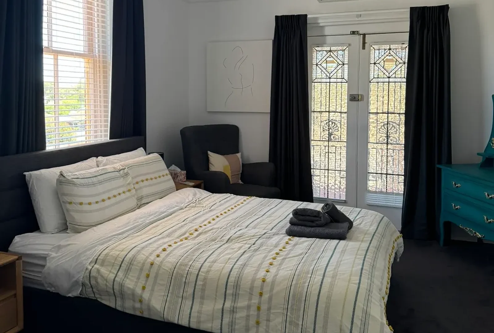 image-3 A bed room with a black chair and a window